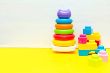 Renkli piramit, inşaatçı, çocuklar için oyuncak blokları beyaz sarı arka planda oynuyor, bebeğin çocukluk gelişimi, küçük çocuğun konsepti için eğitici mantık oyuncakları.