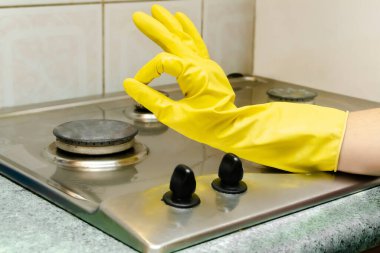 Kirli gaz sobasını yağdan temizlemek, yemek artıkları. Kadın eli koruyucu eldivenle mutfak sobasını yıkıyor. ev temizliği hizmeti kavramı.