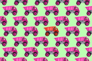 Renkli pembe plastik damperli kamyon, bahşiş kamyonu, yeşil arka planda izole edilmiş araba oyuncağı asimetrik iz, model, şablon, çocuklar için oyuncaklar, kızlar için gelişim, oyun, çocukluk.