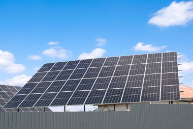 view of new modern residential house cottage with blue shiny solar photo voltaic panels system on roof. Renewable ecological eco green energy production concept.