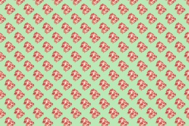 Yeşil arka planda çiğ domuz eti dilimleri ve bifteklerle kusursuz yemek kalıpları. Üst Manzara. Yemekler düzdü..