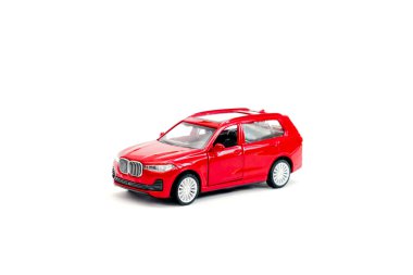 Renkli küçük kırmızı plastik sedan araba oyuncağı beyaz arka planda izole edilmiş fotokopi alanı, çocuklar için oyuncaklar, çocuklar için gelişim, oyun, çocukluk eğlencesi.