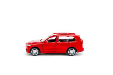 Renkli küçük kırmızı plastik sedan araba oyuncağı beyaz arka planda izole edilmiş fotokopi alanı, çocuklar için oyuncaklar, çocuklar için gelişim, oyun, çocukluk eğlencesi.