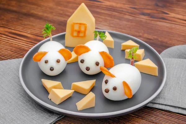 Küçük tavuk yumurtası faresi, havuç kulaklı fareler tabakta peynir, yaratıcı, eğlenceli yemekler, çocuk partisi için sağlıklı öğle yemeği fikri. Ürkütücü Cadılar Bayramı tatlı ikramları için menü, yenilebilir şirin fare seçici odak.
