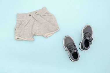 Yazlık bebekler mavi kıyafetler ve gri şortlu aksesuarlar, spor ayakkabılar. Modern moda çocuk kıyafetleri. Bahar ya da yaz için çocuk kıyafetleri. Düz konum, üst görünüm, genel görünüm, kopyalama alanı ile modelleme