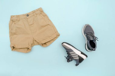 Yaz bebekleri mavi kıyafetler ve kot şortlu aksesuarlar, spor ayakkabılar. Modern moda çocuk kıyafetleri. Bahar ya da yaz için çocuk kıyafetleri. Düz konum, üst görünüm, genel görünüm, kopyalama alanı ile modelleme