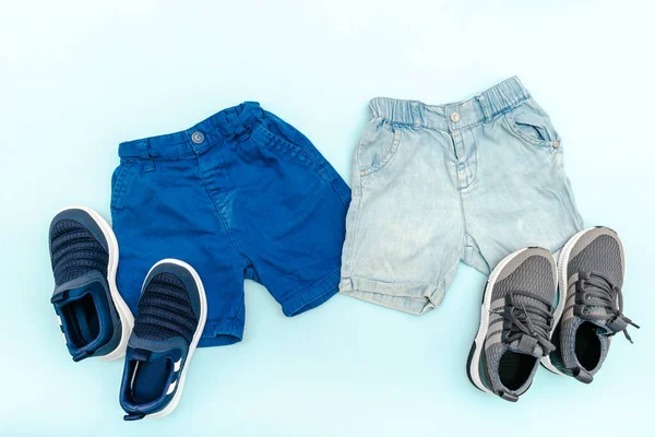 Summer babies blue clothes and accessories with jeans shorts,sneakers. Modern fashion kids outfit.Set of childrens clothing for spring or summer. Flat lay, top view,overhead,mockup —  Fotos de Stock