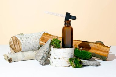 Cam damlatan kahverengi şişe kozmetik yağı, krem, gerekli ağaç kökü podyumunda serum, ağaç kabuğu ağacı, yeşil yosun. Doğal organik eko kaplıca, ilaç kavramı. Bitkisel homeopatik ürünler..