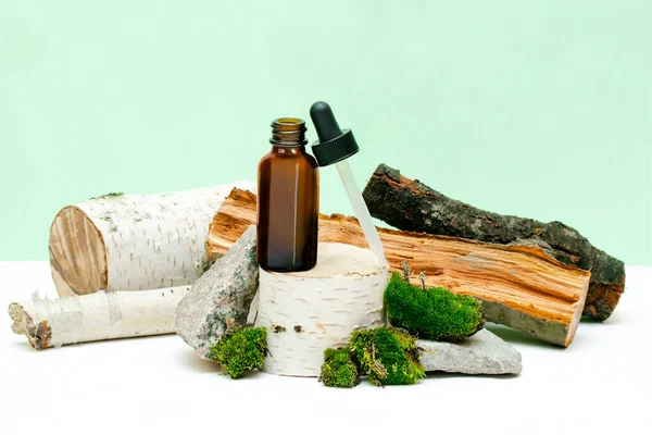 Cam damlatan kahverengi şişe kozmetik yağı, krem, gerekli ağaç kökü podyumunda serum, ağaç kabuğu ağacı, yeşil yosun. Doğal organik eko kaplıca, ilaç kavramı. Bitkisel homeopatik ürünler..