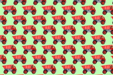 Renkli kırmızı plastik damperli kamyon, bahşiş kamyonu, yeşil arka planda izole edilmiş araba oyuncağı hala kusursuz desen, model, şablon, çocuklar için oyuncaklar, kızlar, gelişim, oyun, çocukluk.