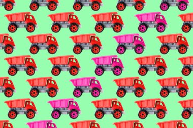 Renkli pembe plastik damperli kamyon, bahşiş kamyonu, yeşil arka planda izole edilmiş araba oyuncağı asimetrik iz, model, şablon, çocuklar için oyuncaklar, kızlar için gelişim, oyun, çocukluk.