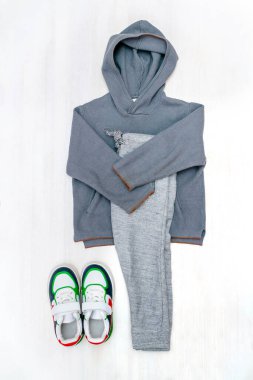 Spor ayakkabılı kazak ve kot pantolon. Beyaz arka planda bahar, sonbahar ya da yaz için bebek kıyafetleri ve aksesuarlar. Moda çocuk kıyafeti. Düz yatıyordu, üstten, yukarıdan..