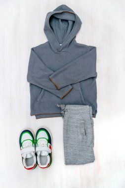 Spor ayakkabılı kazak ve kot pantolon. Beyaz arka planda bahar, sonbahar ya da yaz için bebek kıyafetleri ve aksesuarlar. Moda çocuk kıyafeti. Düz yatıyordu, üstten, yukarıdan..