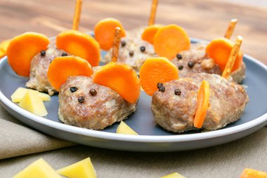 Küçük köfte faresi, havuç kulaklı köfte, tabakta peynir, çocuk partisi için yaratıcı ve eğlenceli yiyecek fikri. Ürkütücü Cadılar Bayramı tatlı ikramları için menü, yenilebilir şirin fare seçici odak.