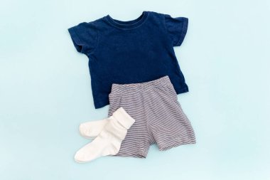 Summer babies blue clothes and accessories with t shirt,shorts,socks. Modern fashion kids outfit.Set of children's clothing for spring or summer. Flat lay, top view,overhead,mockup.