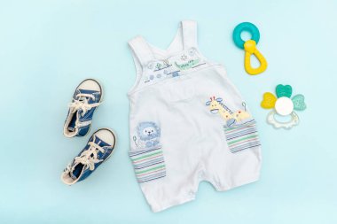Cute baby rompers,bodysuit, sneakers with toys,teethers. Set of kids,childrens clothes and accessories in blue color. newborn,infant fashion, outfit. Flat lay, top view.