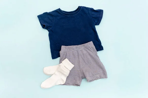 Summer babies blue clothes and accessories with t shirt,shorts,socks. Modern fashion kids outfit.Set of children\'s clothing for spring or summer. Flat lay, top view,overhead,mockup.