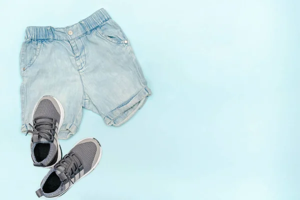 Summer babies blue clothes and accessories with jeans shorts,sneakers. Modern fashion kids outfit.Set of children\'s clothing for spring or summer. Flat lay, top view,overhead,mockup with copy space.