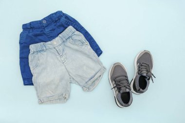 Summer babies blue clothes and accessories with jeans shorts,sneakers. Modern fashion kids outfit.Set of children's clothing for spring or summer. Flat lay, top view,overhead,mockup.