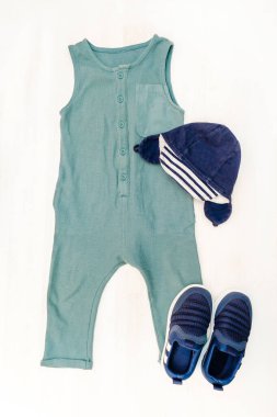Şirin bir bebek tulumu, panama şapkalı spor ayakkabıları. Çocuklar, çocuk kıyafetleri ve pastel mavisi aksesuarlar. Yeni doğan, bebek modası, kıyafet. Düz yatış, üst görünüm, model.