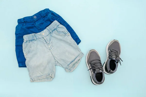 Summer babies blue clothes and accessories with jeans shorts,sneakers. Modern fashion kids outfit.Set of children\'s clothing for spring or summer. Flat lay, top view,overhead,mockup.