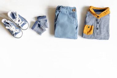 Farklı çocuk kıyafetleri, ayakkabıları, ayakkabıları, pantolonları, aksesuarları fotokopi masası, düz yataklar. Bebek partisi, dekorasyon, eşyalar, erkek çocuğun doğum günü hediyesi, yeni doğan partisi..