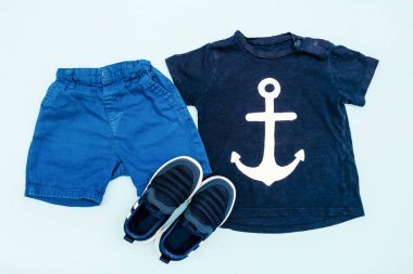 Yaz bebekleri mavi elbiseler ve tişörtlü aksesuarlar, şort, spor ayakkabılar. Modern moda çocuk kıyafetleri. Bahar ya da yaz için çocuk kıyafetleri. Düz yatış, üst görünüm, genel görünüş, model.