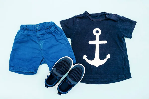 Summer babies blue clothes and accessories with t shirt, shorts,sneakers. Modern fashion kids outfit.Set of children\'s clothing for spring or summer. Flat lay, top view,overhead,mockup.