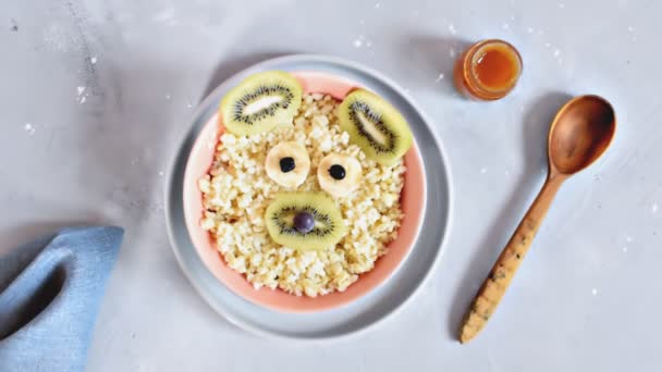 视频动画滑稽可爱的孩子们婴儿健康的早餐粥在碗里看起来像熊 老鼠的脸与香蕉 猕猴桃 甜点食品艺术 — 图库视频影像