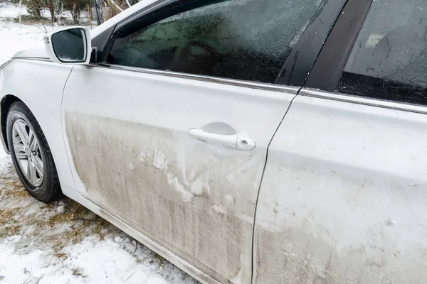 Dirty car automobile at home backyard outdoor at winter snowy day. Vehicle before cleaning at car wash garage station.