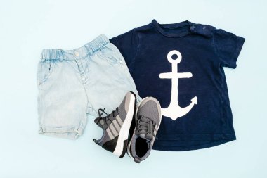 Yaz bebekleri mavi elbiseler ve tişörtlü aksesuarlar, şort, spor ayakkabılar. Modern moda çocuk kıyafetleri. Bahar ya da yaz için çocuk kıyafetleri. Düz yatış, üst görünüm, genel görünüş, model.