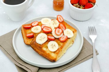 Square belgian waffles with strawberries berries,bananas,condensed milk,honey on plate, cup of coffee espresso. Tasty breakfast, sweet dessert food.selective focus, close up top view flat lay.