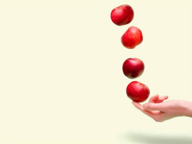 Flying levitating floating red ripe fresh juicy apples in air above female womens hand on green background. Levity summer fruits. Trendy, minimal Creative food.healthy nutrition,copy space