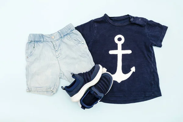 Summer babies blue clothes and accessories with t shirt, shorts,sneakers. Modern fashion kids outfit.Set of children\'s clothing for spring or summer. Flat lay, top view,overhead,mockup.