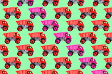 Renkli pembe plastik damperli kamyon, bahşiş kamyonu, yeşil arka planda izole edilmiş araba oyuncağı asimetrik iz, model, şablon, çocuklar için oyuncaklar, kızlar için gelişim, oyun, çocukluk.