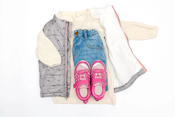 Vest,warm jumper,sweater,jeans pants,pink sneakers.Set of baby children\'s clothes,clothing for spring,autumn,winter on white background. Fashion girls kids outfit.Flat lay,top view, overhead,mockup.