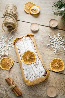 Ahşap arka planda Noel çalıntısı. Geleneksel yeni yıl Alman tatlı tatlısı. Fındıklı kek, portakal, badem ezmesi, pudra şekeri ve masada kurutulmuş meyve. Noel arifesi için yemek pişiriyorum..