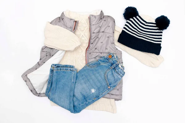 Vest,warm jumper,sweater,jeans pants,knitted cap,hat.Set of baby children clothes,clothing,accessories for spring,autumn,winter on white background. Fashion girls kids outfit.Flat lay,top view,mockup.