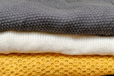 Kışlık kıyafetlerle dolu bir gardırop. Katlanmış kaşmir yığını, sıcak yün örgü süveterler, günlük kadın kıyafetleri. Sonbahar, kış soğuk mevsimlik örgü.