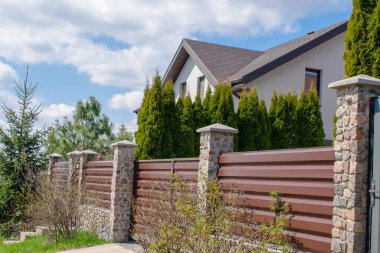 private suburban house with backyard behind high fence. beautiful landscape recreation cottage complex in ecological area with green thuja hedge. Modern architecture, riches and luxury concept.