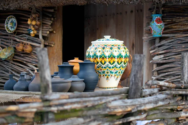 Different clay dishes tableware cooking pots, jars, souvenirs on wooden background at artisan market. Set of antique pottery craft ceramic. national slavic handmade clay ware,ukrainian heritage.
