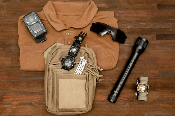 特种部队士兵警察的战术装备 如军用弹药 手电筒 对讲机 身体摄像头 木制背景配件等 生存远足的评估 — 图库照片