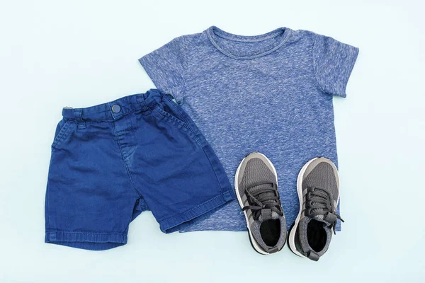 Summer babies blue clothes and accessories with t shirt, shorts,sneakers. Modern fashion kids casual outfit.Set of childrens clothing for spring. Flat lay, top view,overhead,mockup.