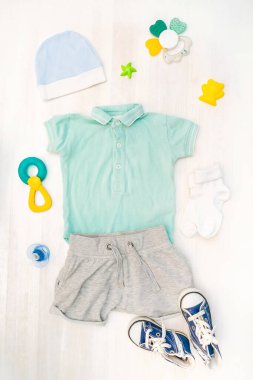 Cute baby romper,bodysuit,shorts,hat, socks,sneakers with toys,teethers. Set of kids,childrens clothes and accessories in pastel blue color. Newborn,infant fashion, outfit. Flat lay, top view.