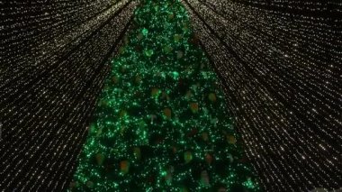 Şehir merkezinde güzel çelenkleri olan Noel ağacı.