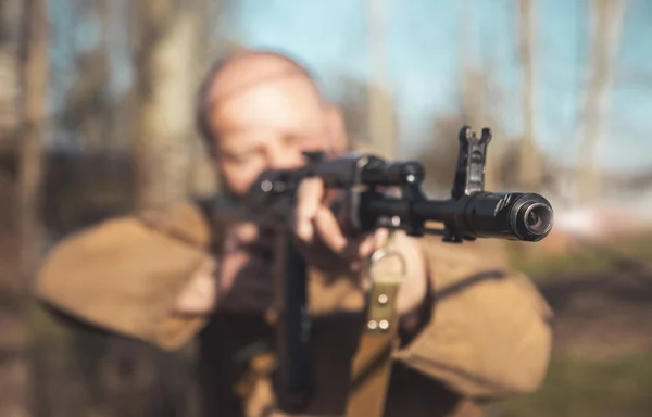 Muzzle of a machine gun close-up in the hands of a man — Stock fotografie