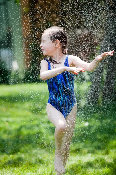 Fata într-un costum de baie rulează în grădină Imagini stoc fără drepturi de autor