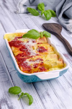 Ahşap zemin üzerinde et ve sos bulunan geleneksel pişmiş cannelloni. Seçici odak. 