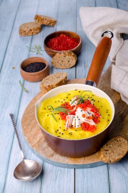 Sarı püre, yengeç eti ve kırmızı havyar. Ahşap arka plan. Seçici odak.