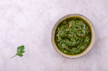 Seramik tabaklarda yeşil sos, gri taşlı arka planda. Seçici odaklanma. Üst görünüm.